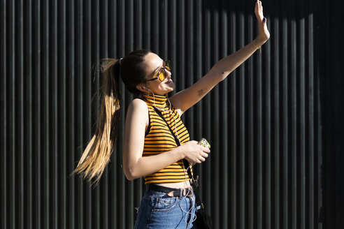 Glückliches Teenager-Mädchen mit Kopfhörern und Smartphone genießt den Sonnenschein - ERRF00856