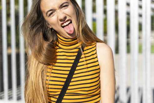 Porträt eines Mädchens im Teenageralter, das die Zunge herausstreckt - ERRF00862