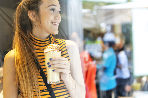 Spanien, lächelndes Teenager-Mädchen, das einen Milchshake genießt, lizenzfreies Stockfoto