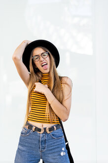Porträt eines Teenagers mit Hut und Brille, der die Zunge herausstreckt - ERRF00876