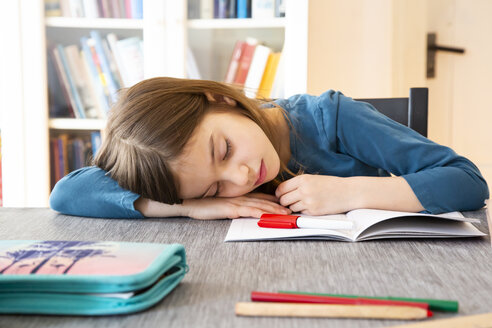 Schoolgirl napping at table with homework - LVF07943