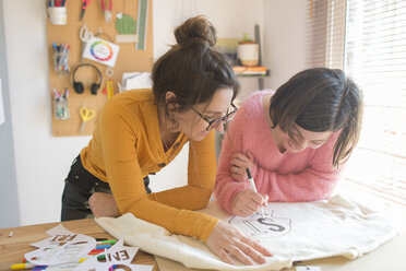 Two women drawing stencils for printing sweatshirts - SKCF00578