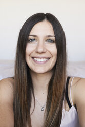 Porträt einer glücklichen jungen Frau mit langen braunen Haaren - IGGF00934