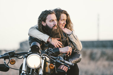 Portrait of couple on motorbike looking at distance - OCMF00355