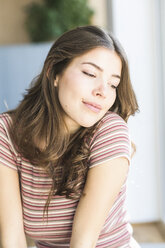 Portrait of young woman at home daydreaming - UUF16998