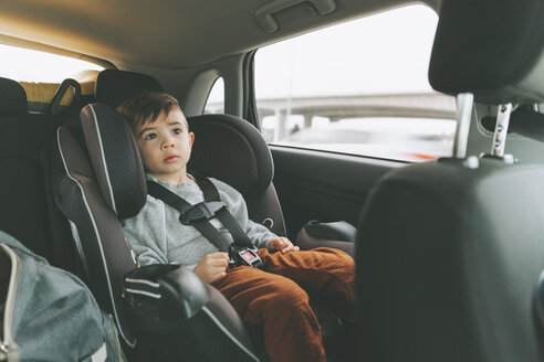 Kleiner Junge sitzt im Auto auf einem Kindersitz mit angelegtem Sicherheitsgurt - CMSF00001