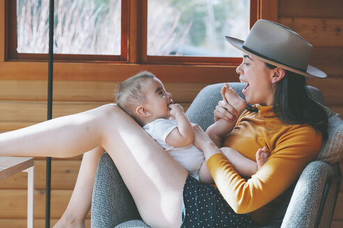 Mutter spielt mit ihrem kleinen Sohn in einer Holzhütte - CMSF00015