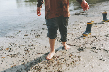 Junge spielt am Strand, läuft barfuß im Schlamm - CMSF00023