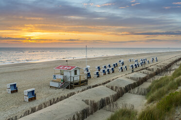 Germany, Sylt, North Sea, sandy beach with hooded beach chairs in sunset - MKFF00485