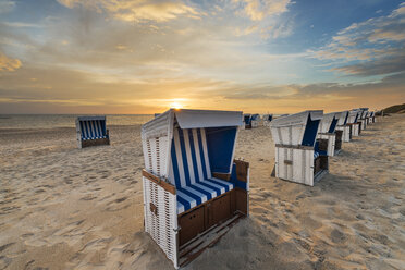 Germany, Sylt, North Sea, sandy beach with hooded beach chairs in sunset - MKFF00486