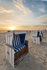 Germany, Sylt, North Sea, sandy beach with hooded beach chairs in sunset - MKFF00487