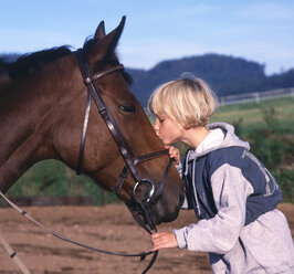 Girl kissing a horse affectionately - WWF04914