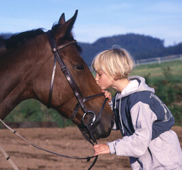 Mädchen küsst liebevoll ein Pferd - WWF04914