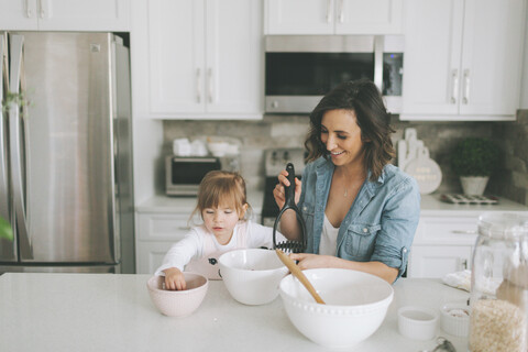 Mother and daughter making a cake together stock photo