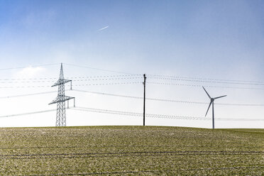 Germany, Baden-Wuerttemberg, Taubertal, power pylons in field - EGBF00293