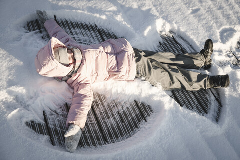 Little girl making a snow angel stock photo