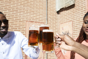 Drei glückliche Freunde trinken Bier in einer Bar im Freien - IGGF00950