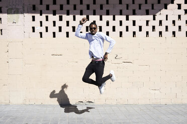 Happy young man jumping in the air - IGGF00956