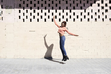 Happy young woman jumping in the air - IGGF00958