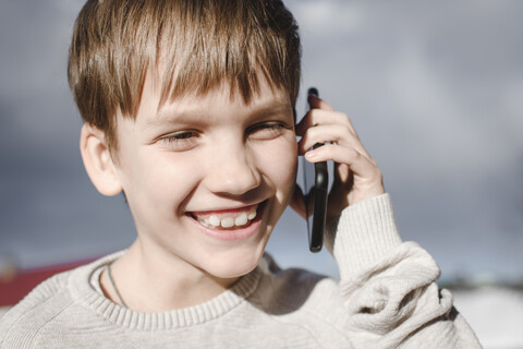 Portrait of happy boy on cell phone stock photo