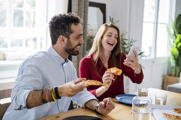 Friends having fun, eating pizza, using smartphone - GIOF06086