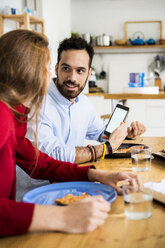 Freunde haben Spaß, essen Pizza, benutzen Smartphone - GIOF06097