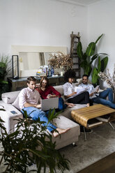 Freunde sitzen auf der Couch, arbeiten zwanglos zusammen, benutzen - GIOF06118