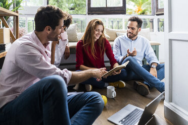 Friends having an casual work meeting, discussing documents - GIOF06133