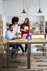 Freunde arbeiten gemeinsam an einem Projekt in ihrem Loftbüro - GIOF06176