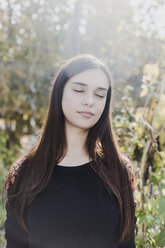 Portrait of woman with closed eyes in urban garden - VGPF00021