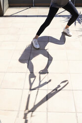Silhouette shadow of woman doing suspension training on terrace - IGGF00963