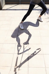 Silhouettenschatten einer Frau beim Suspensionstraining auf einer Terrasse - IGGF00963