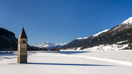 Italien, Vinschgau, Versunkene Turmspitze im zugefrorenen Reschensee im Winter - STSF01904