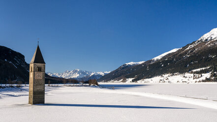 Italy, Venosta Valley, Sunken spire in frozen Lago di Resia in winter - STSF01904