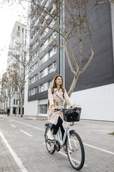Woman riding e-bike in the city - JRFF02889