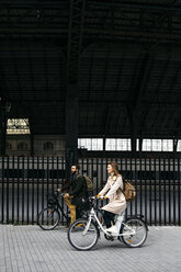 Couple riding e-bikes in the city - JRFF02906