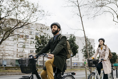 Ein Paar fährt E-Bikes in der Stadt - JRFF02910