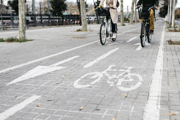 Ein Paar fährt mit einem E-Bike in der Stadt auf dem Fahrradweg - JRFF02912