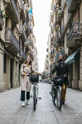 Couple pushing e-bikes exploring the city - JRFF02919