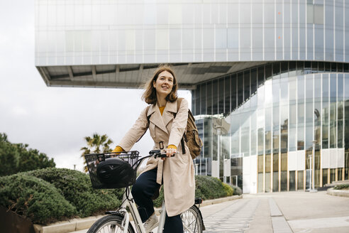 Porträt einer Frau auf einem E-Bike in der Stadt - JRFF02921