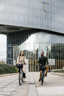 Ein Paar fährt E-Bikes in der Stadt - JRFF02924