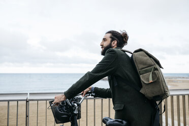 Mann mit E-Bike bei einer Pause auf der Strandpromenade - JRFF02936