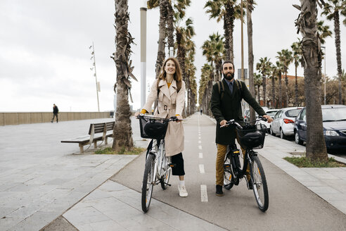 Porträt eines Paares mit E-Bikes auf einer Promenade - JRFF02941