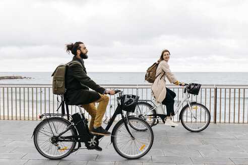 Pärchen auf E-Bikes an der Strandpromenade - JRFF02948