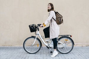 Frau mit E-Bike an einer Wand - JRFF02975