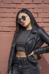 Portrait of young woman wearing sunglasses and black leather jacket - OCMF00373