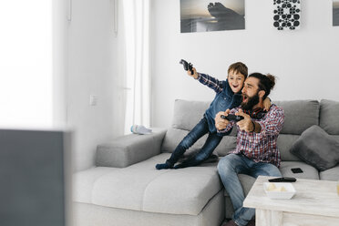 Vater und Sohn spielen zusammen zu Hause ein Computerspiel - JRFF03000