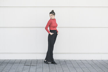 Elegant young woman standing at a wall - UUF17033