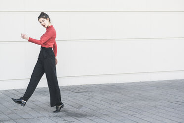 Elegant young walking along a wall - UUF17038