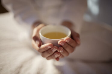 Close up woman cupping hot tea - HOXF04404